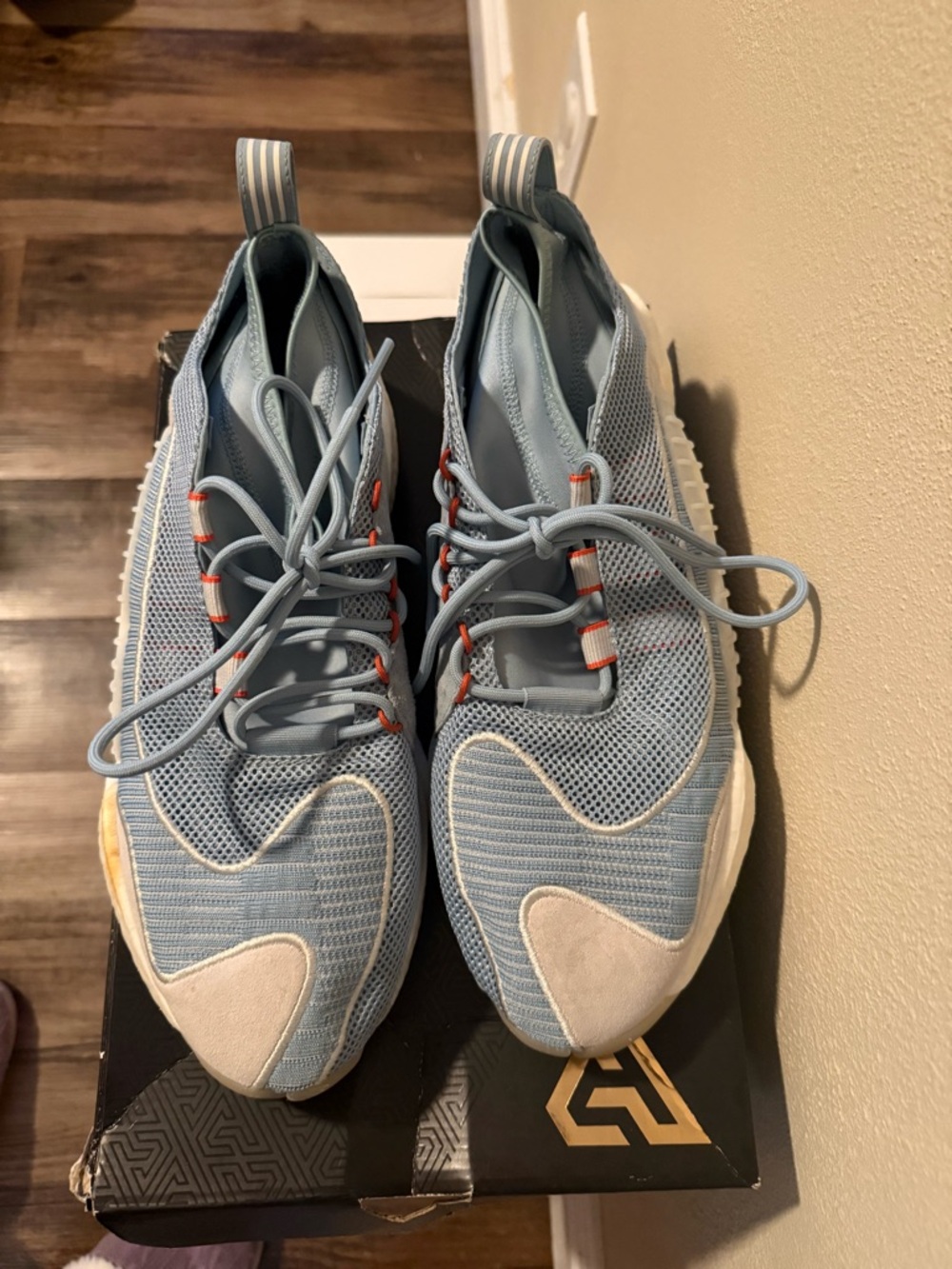 Light Blue Adidas Athletic Sneakers with Orange Accents.